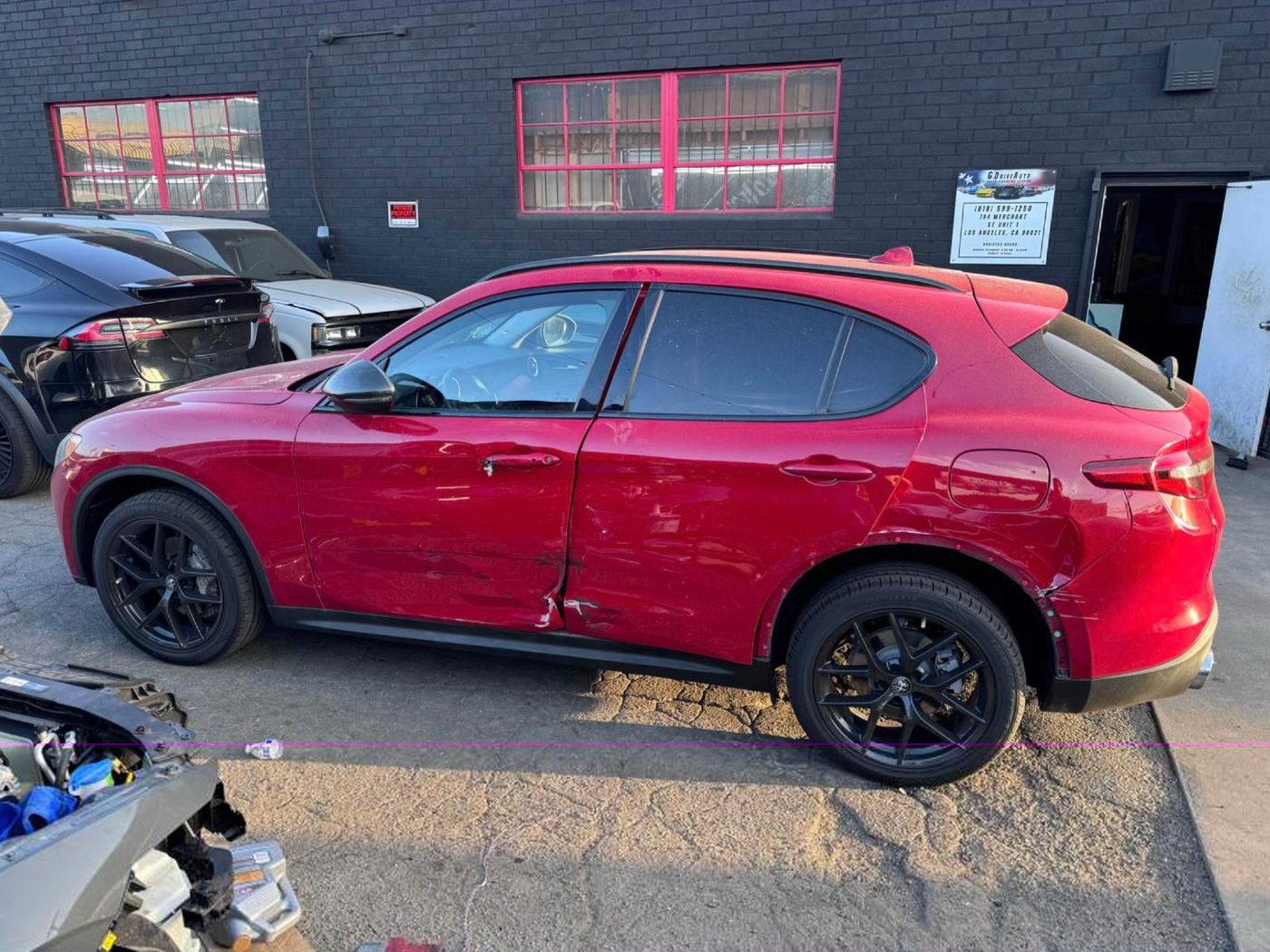 Red Alfa Romeo Stelvio with side damage