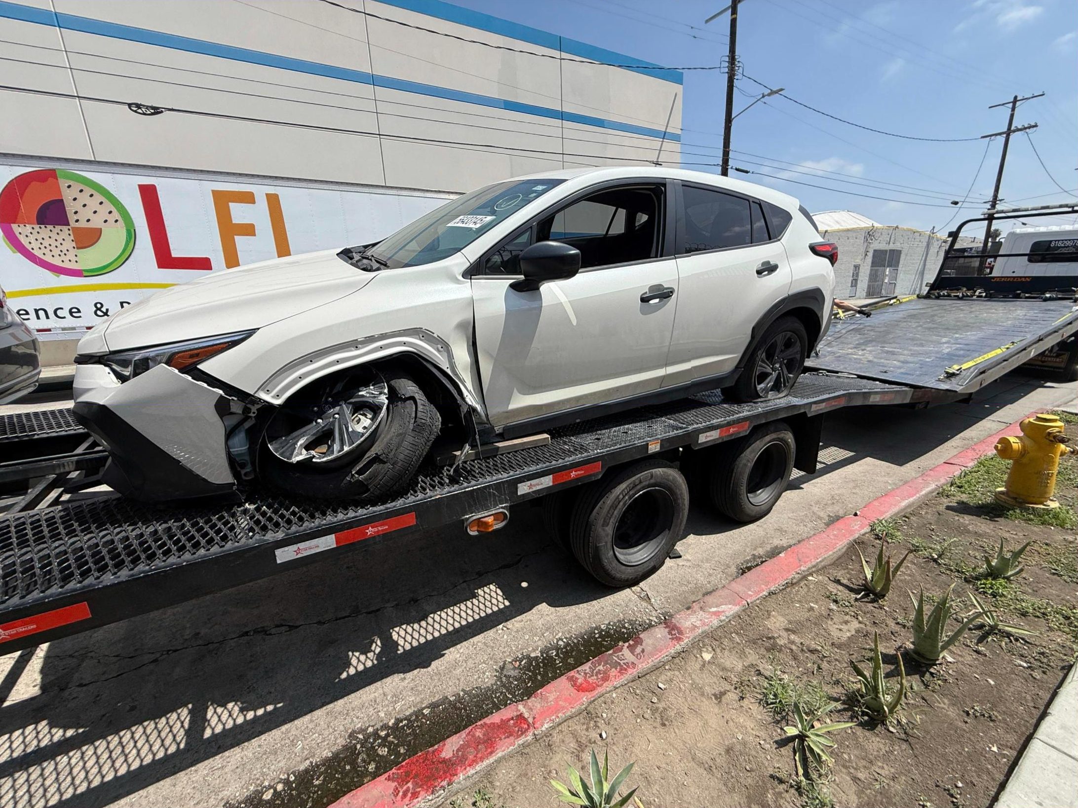 Damaged white SUV on our flatbed